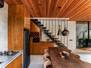 a kitchen with a wooden table and a staircase at Blacksand Villas Canggu in Canggu