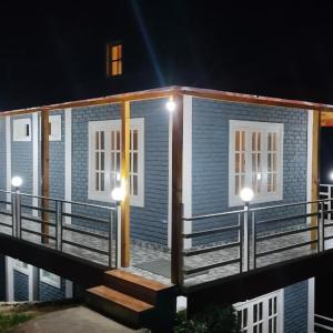 a house with lights on the front of it at Saanidhya Sunset View Villa in Mukteswar