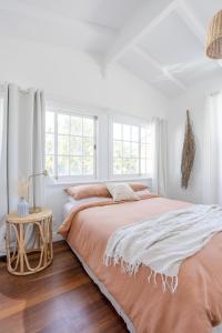 - une chambre blanche avec 2 lits et une table dans l'établissement The Holiday House - Newly listed, à Pottsville