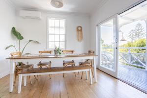 une salle à manger avec un banc et une grande fenêtre dans l'établissement The Holiday House - Newly listed, à Pottsville