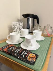 a table with cups and saucers and a coffee pot at Zinnia North Tower 3202 in Manila
