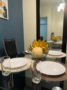 a table with glasses and a bowl of bananas on it at Zinnia North Tower 3202 in Manila