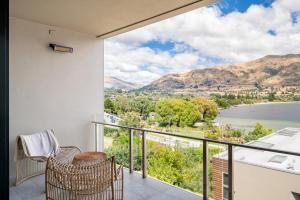 a balcony with a view of the water and mountains at Hana Apartment by Sotheby's Luxury Rental Homes in Wanaka