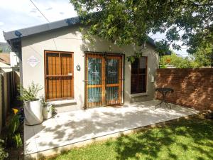 a small white house with a table in a yard at Harrismith Country Cottage in Harrismith