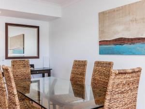 a dining room with a glass table and chairs at Sunrise Cove 12 in Kingscliff +12 photos