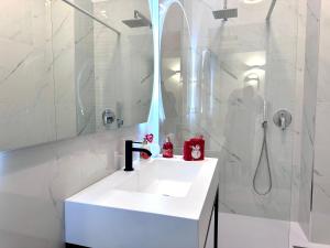 a white bathroom with a sink and a shower at Boutique Apartment Trieste in Trieste +16 photos
