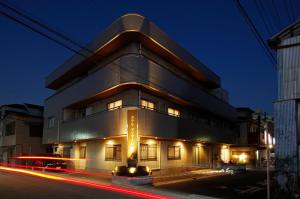 un bâtiment avec des lumières devant lui la nuit dans l'établissement Hotel Imalle Haneda, à Kawasaki