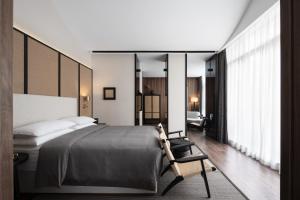 a bedroom with a large bed and a chair at Yijian Hotel Wuyi Square Chaozong Street in Changsha