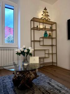 a living room with a glass table with a vase of flowers at Boutique Apartment Trieste in Trieste
