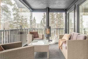 a screened in porch with furniture and a fireplace at Villa Länsihuippu in Himos