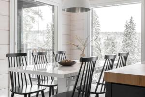 a white dining room with a white table and chairs at Villa Länsihuippu Incl WiFi, Pool table, AC, Jacuzzi for extra fee in Himos