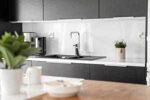 a kitchen with a sink and black cabinets at Villa Länsihuippu Incl WiFi, Pool table, AC, Jacuzzi for extra fee in Himos