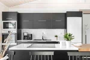 a kitchen with black cabinets and a white counter top at Villa Länsihuippu Incl WiFi, Pool table, AC, Jacuzzi for extra fee in Himos