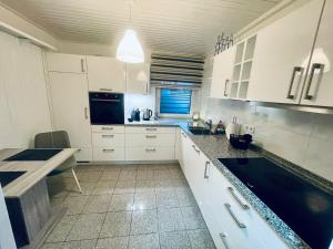a kitchen with white cabinets and a black counter top at Appartement 3 - geräumige Wohnung mit eigener Küche, Bad und Gartenblick in Salzgitter