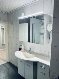 a white bathroom with a sink and a mirror at Appartement 3 - geräumige Wohnung mit eigener Küche, Bad und Gartenblick in Salzgitter