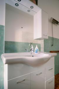 un bagno con un lavandino bianco e uno specchio di Villa Fiorelli rooms a Roma Altre 21 foto