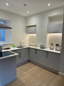a large kitchen with white counters and white cabinets at Town centre apartment in Kendal