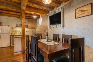 eine Küche mit Holztisch und Kühlschrank in der Unterkunft Vineyard Cottage Skatlar 2 in Srednje Grčevje