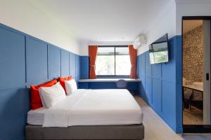 a bedroom with blue walls and a bed with orange pillows at Penpark Place in Bangkok