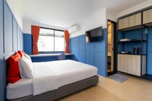 a bedroom with a bed with blue walls and a television at Penpark Place in Bangkok