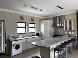 eine Küche mit einer Theke und einer Waschmaschine darin in der Unterkunft Leadwood Flat in Mondesa