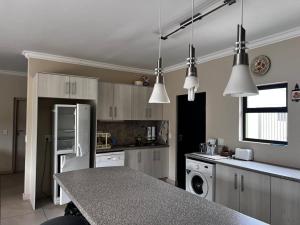 eine Küche mit weißen Schränken und einer Arbeitsplatte in der Unterkunft Leadwood Flat in Mondesa + 5 Fotos