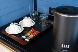 a table with two cups and plates and a tea kettle at Penpark Place in Bangkok