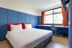 a blue bedroom with a large bed with red pillows at Penpark Place in Bangkok