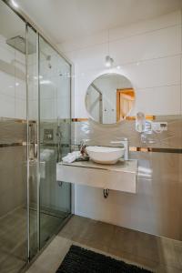 een badkamer met een wastafel en een spiegel bij Topory Prestige House sauna & jacuzzi in Zakopane