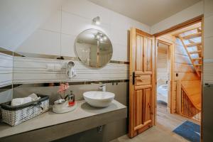 een badkamer met een wastafel en een spiegel bij Topory Prestige House sauna & jacuzzi in Zakopane +12 foto's