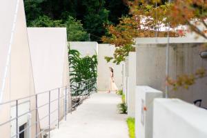 a woman in a dress walking down a sidewalk at Dalto Resort Poolvilla Glamping in Yeongdeok