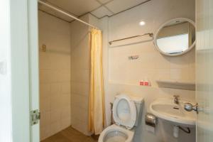 a bathroom with a toilet and a sink and a mirror at Penpark Place in Bangkok