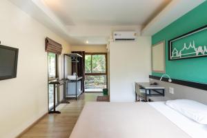 a bedroom with a white bed and a green wall at Penpark Place in Bangkok