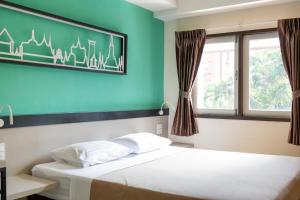 a bedroom with two beds and a green wall at Penpark Place in Bangkok