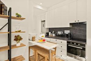 a kitchen with white cabinets and a white table at Lazuli Hermes Apartments in Larnaca