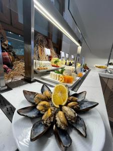 a plate of mussels with a slice of an orange at Sundia By Liberty Suncity in Oludeniz
