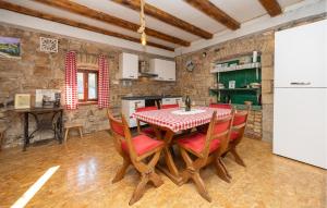 a kitchen with a table with chairs and a refrigerator at Beautiful Apartment In Hrvace With Wifi in Hrvace