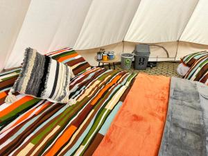 大圣科勒姆Lakeside Glamping Firecrest的帐篷内的一张床位,上面有两个枕头 更多37张照片