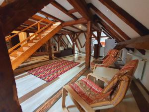 een zolderkamer met twee stoelen en een kleed bij Casa Corona in Braşov