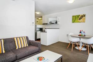 a living room with a couch and a table at BreakFree Adelaide in Adelaide