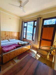 a bedroom with a large bed and a window at त्रिnity homestay in Kasol