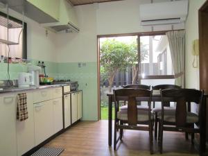 a kitchen with a table and chairs in a room at Enman Guest House Osaka in Osaka