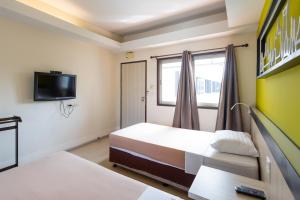 a bedroom with a bed and a tv on the wall at Penpark Place in Bangkok