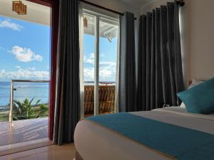 una camera da letto con un letto e vista sull'oceano di Reef Edge Thulusdhoo, Maldives a Thulusdhoo