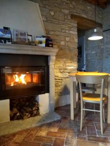 a fireplace in a room with a table and a table and chair at Le Spine B&B sulla Via Francigena in Berceto