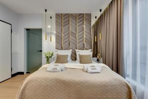 a bedroom with a large bed with two pillows at DOKI Living & Foodhall by Downtown Apartments in Gdańsk