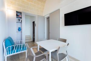a dining room with a white table and chairs at Marinaia-Casa Petra in Diso