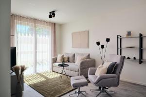 a living room with a couch and two chairs at Apartment B 1 "Pine Hill Resort" Familienfreundlich mit eigenem Fahrradabteil & eingeschränktem Haffblick in Zirchow