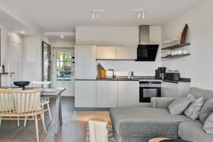 a living room and kitchen with a couch and a table at Alte Schule Westerhever Welt in Westerhever