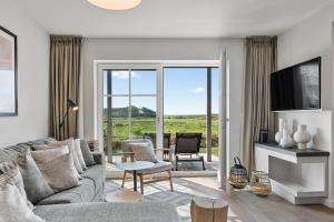 a living room with a couch and a table and chairs at Alte Schule Westerhever Welt in Westerhever